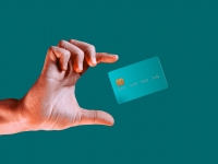 Close up male hand and levitating template mockup bank credit card with online service isolated on green background